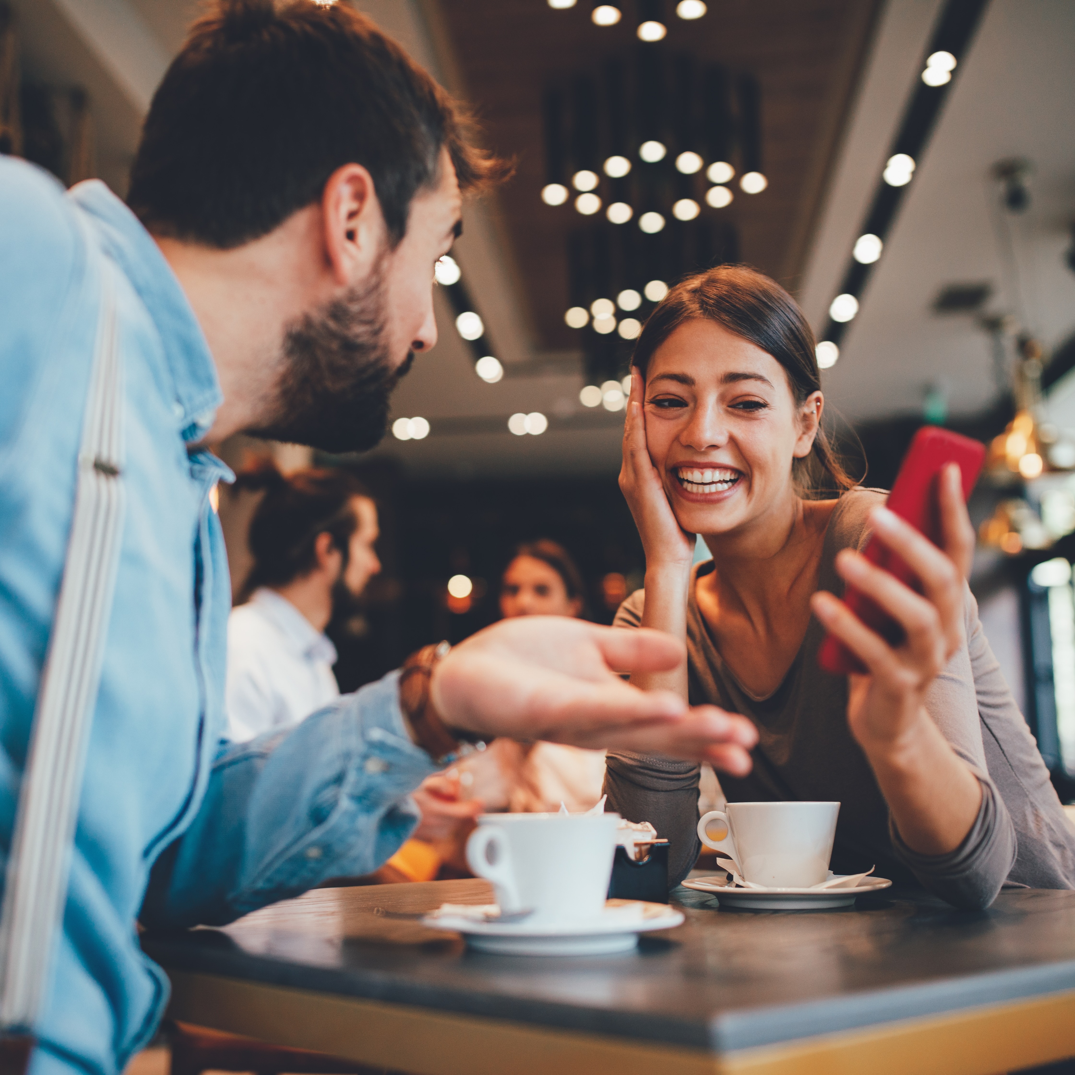 Two people using Tolki at a café — effortless conversation across languages
